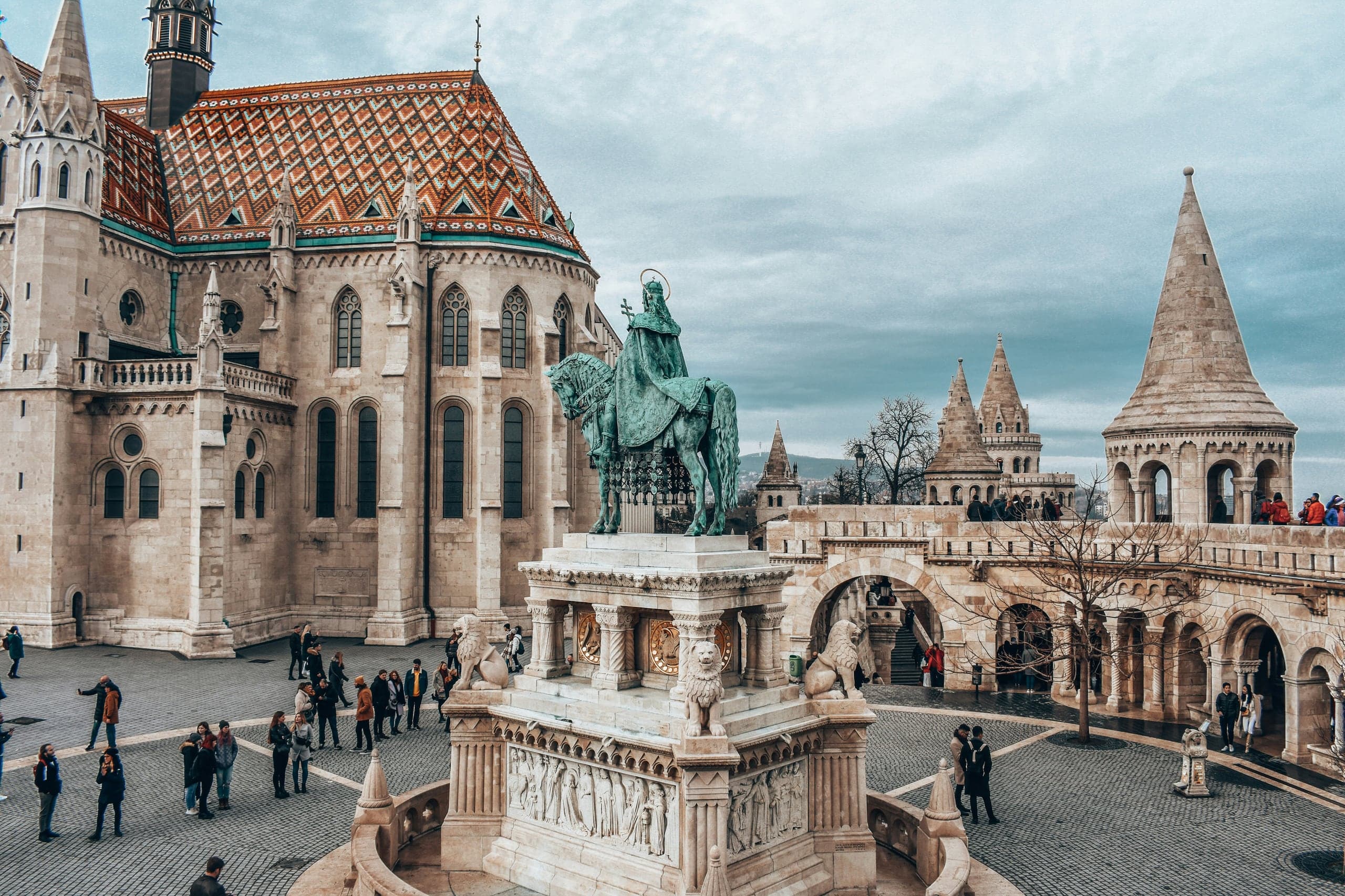 Visitors crossing the pale stone terraces between Matthias Church and the turrets of Fisherman's Bastion