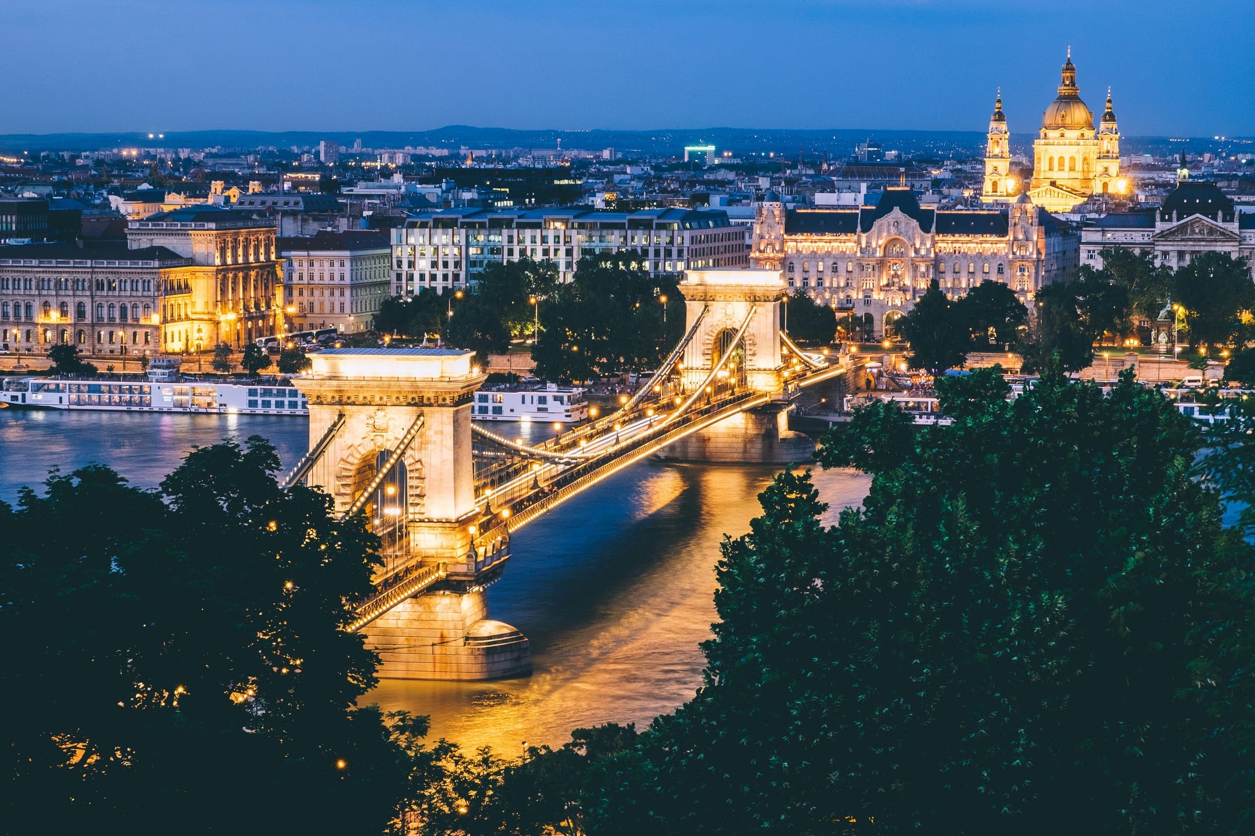 The illuminated Chain Bridge crossing the Danube toward St. Stephen's Basilica at blue hour