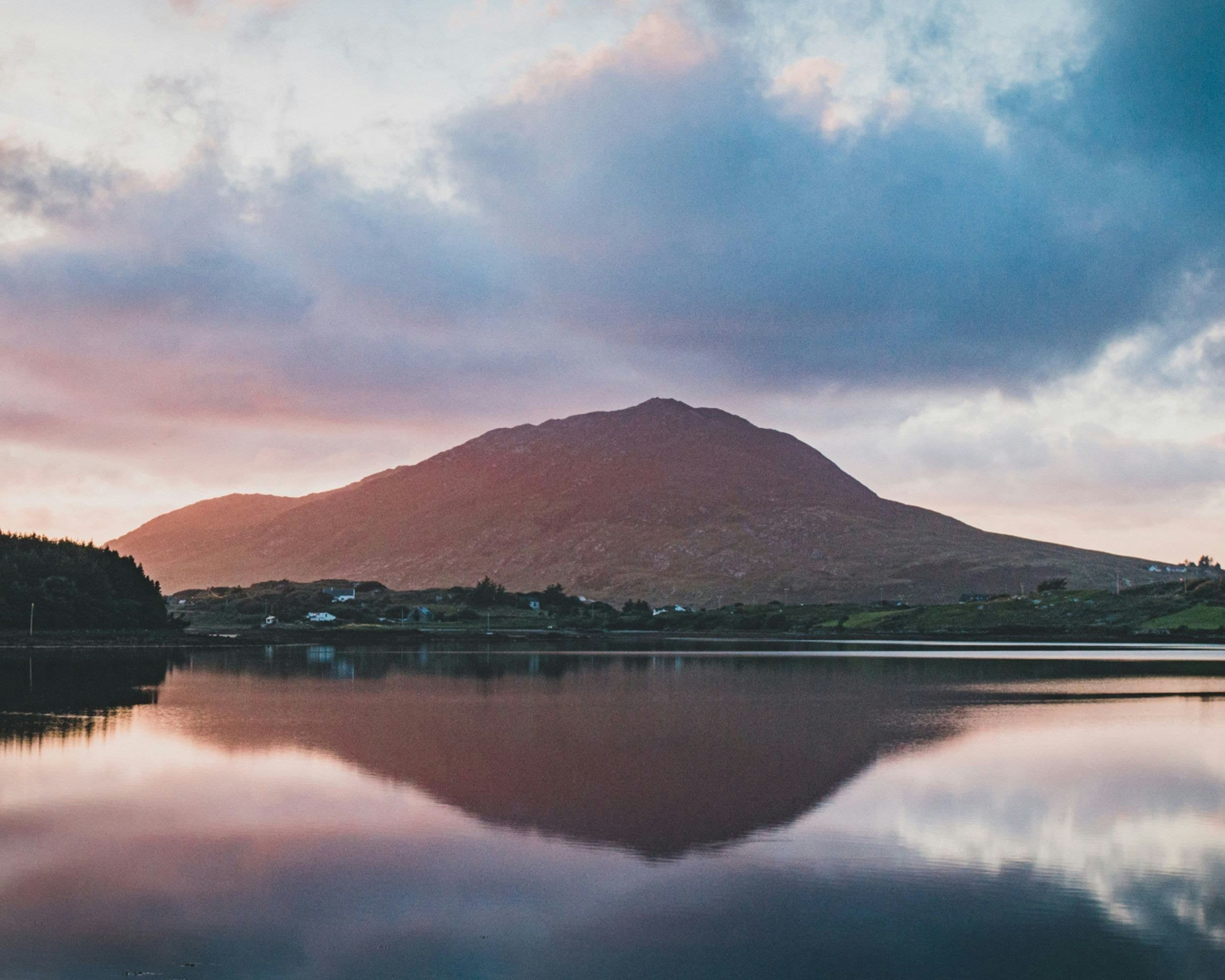 a large body of water with a mountain in the background