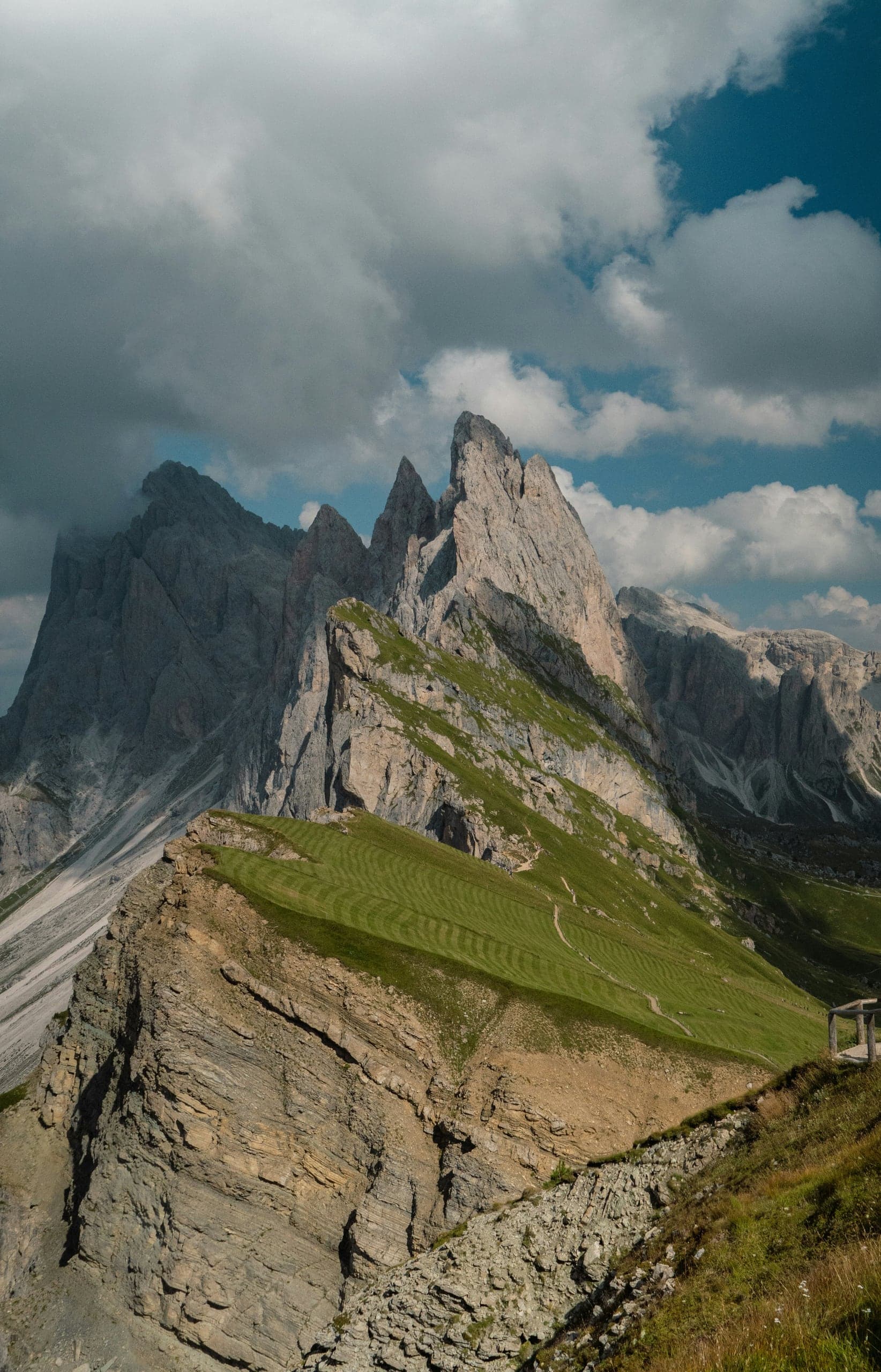 The steep green Seceda ridgeline and jagged Odle outcrops beneath moving cloud