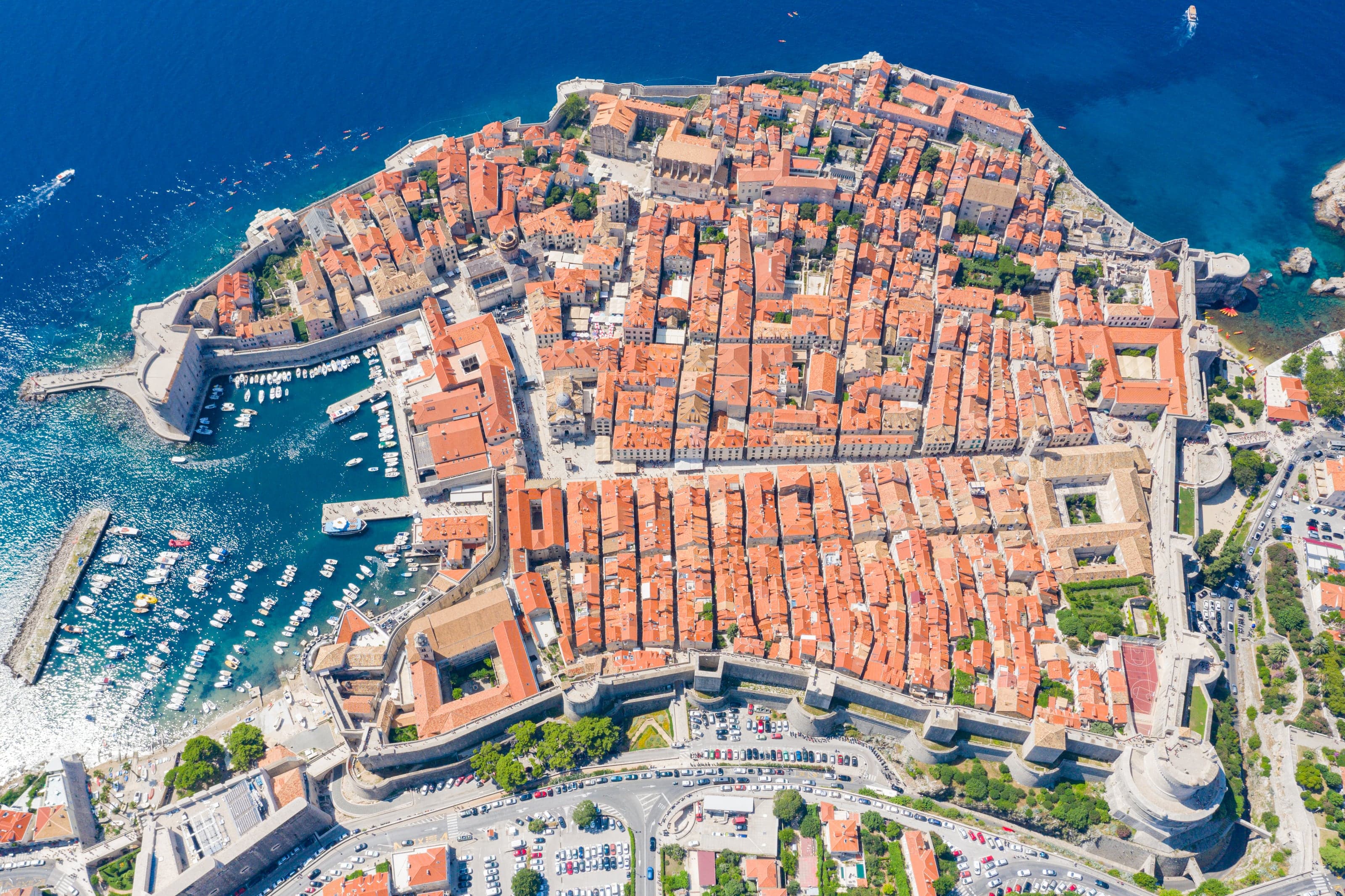 Dubrovnik's complete terracotta-roofed Old Town enclosed by stone walls between two brilliant blue harbors