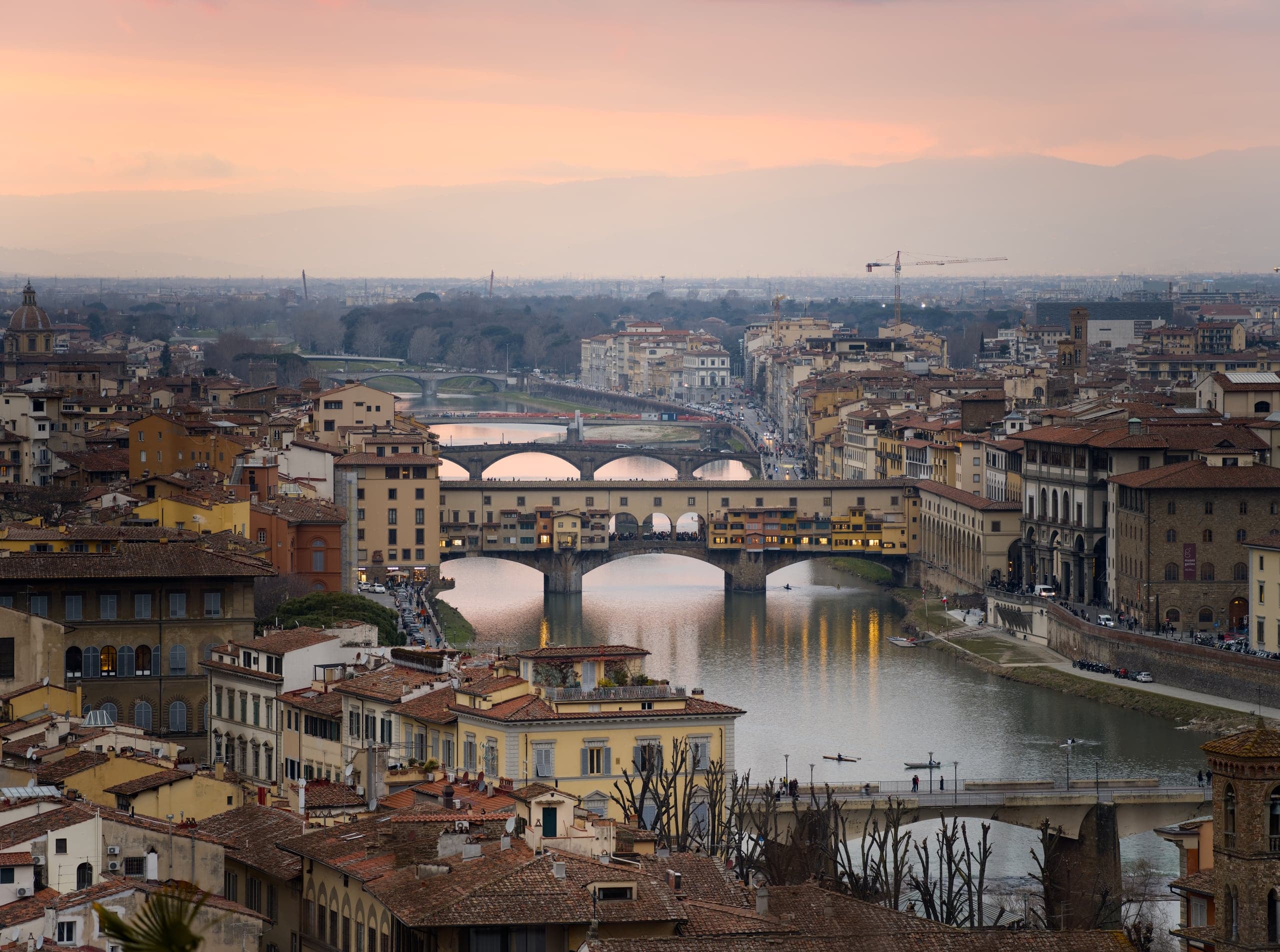 Ponte Vecchio and the Arno glowing beneath a soft Florence sunset