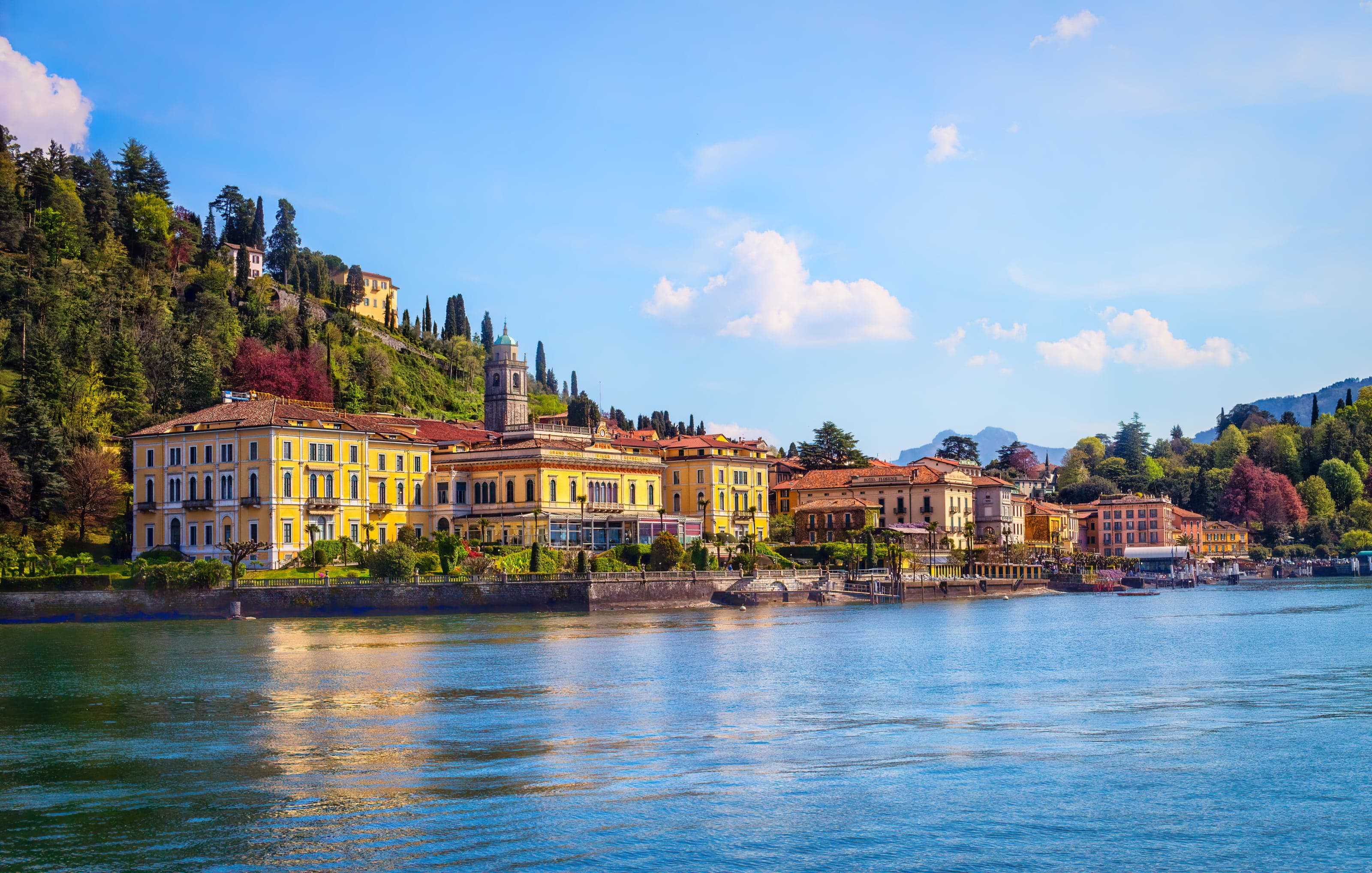 Bellagio's colorful waterfront glowing across the blue water of Lake Como