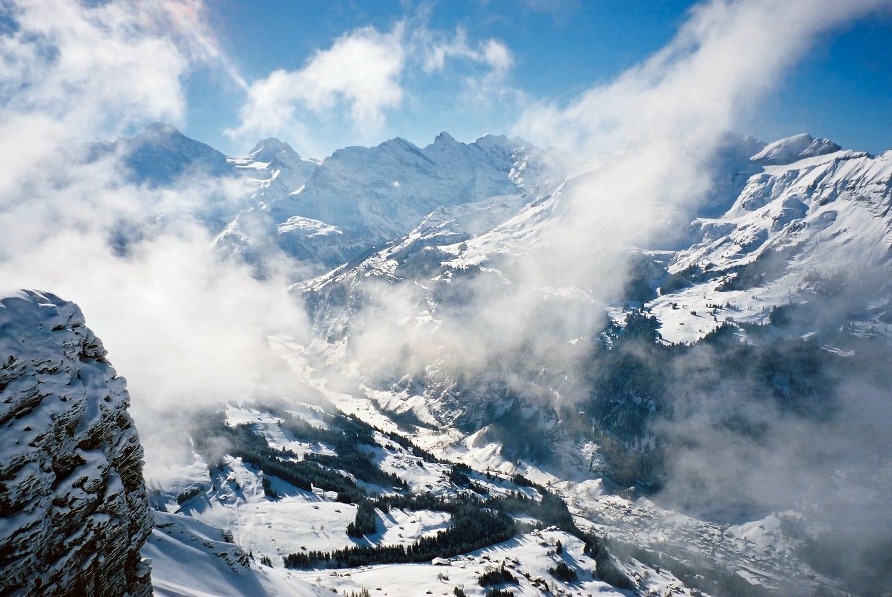 Snow-covered Lauterbrunnen Valley emerging through winter clouds