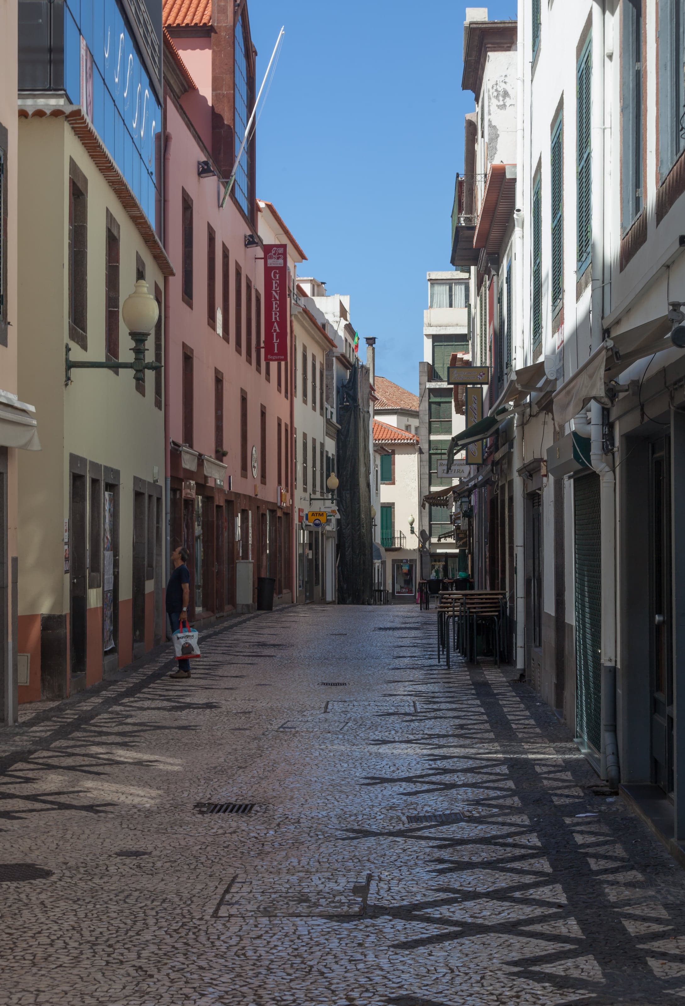 A narrow polished-stone street lined with colorful historic façades in Funchal, Madeira