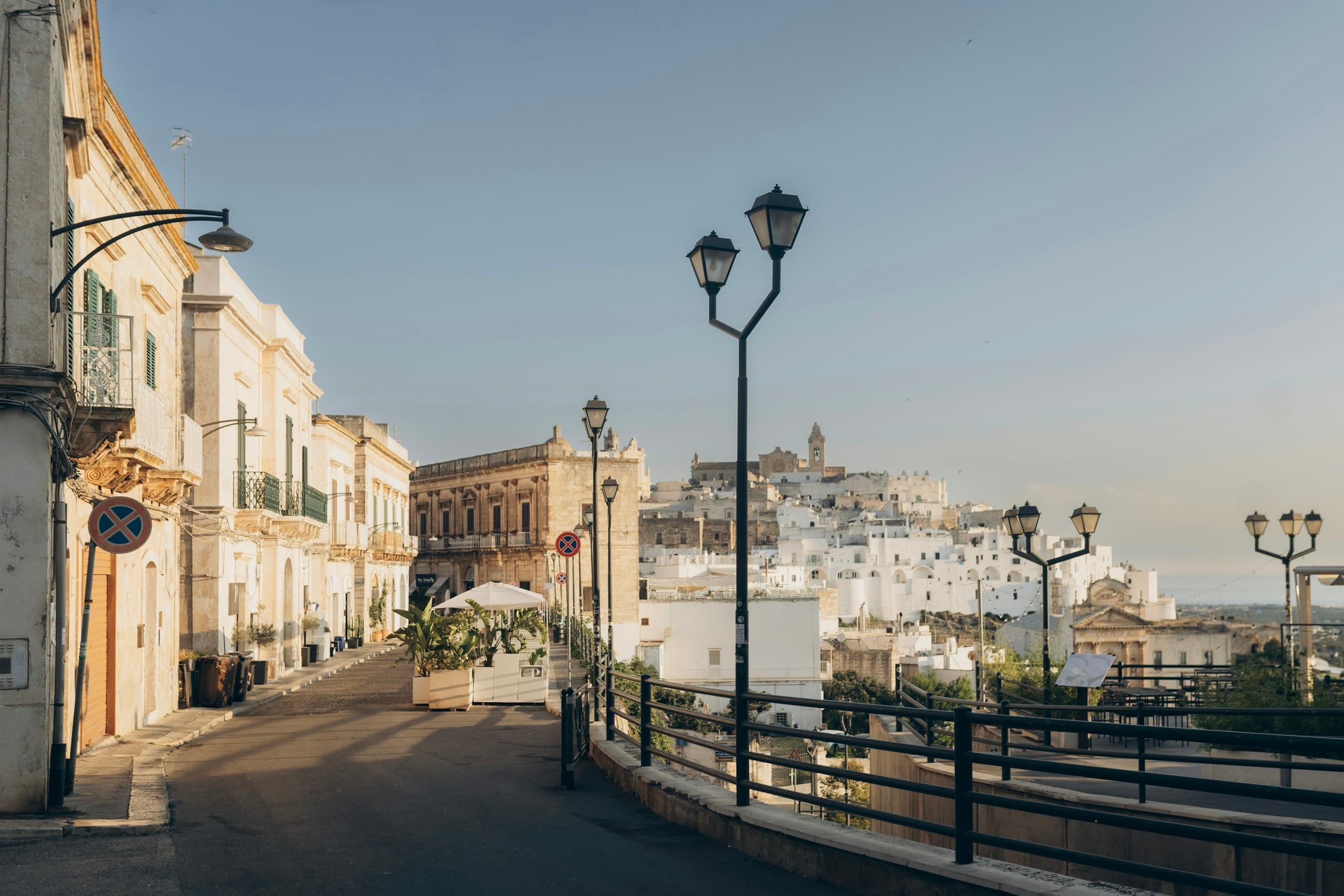 Charming italian street with white buildings and distant town.