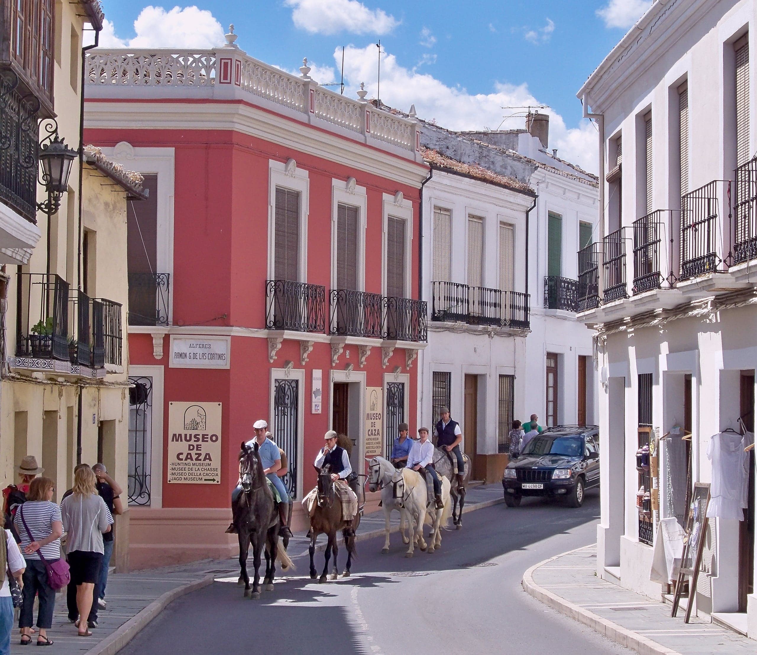 Horse riders passing colorful historic buildings on Calle Armiñán in Ronda