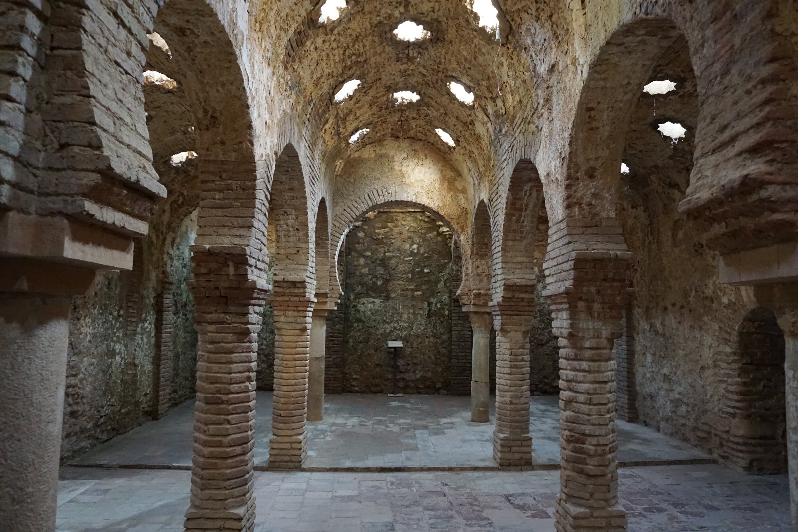Brick arches and star-shaped skylights inside Ronda's medieval Arab Baths