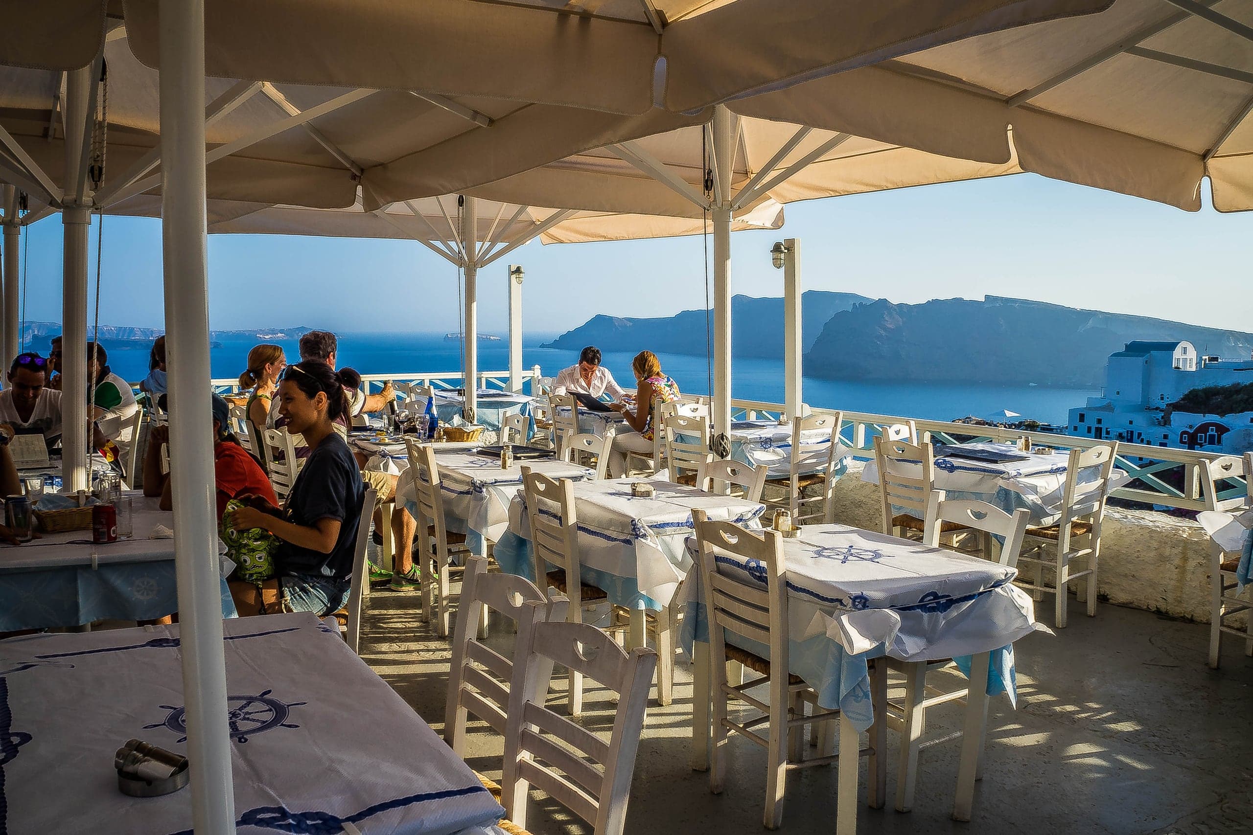 Open-air restaurant terrace overlooking the caldera at Oia