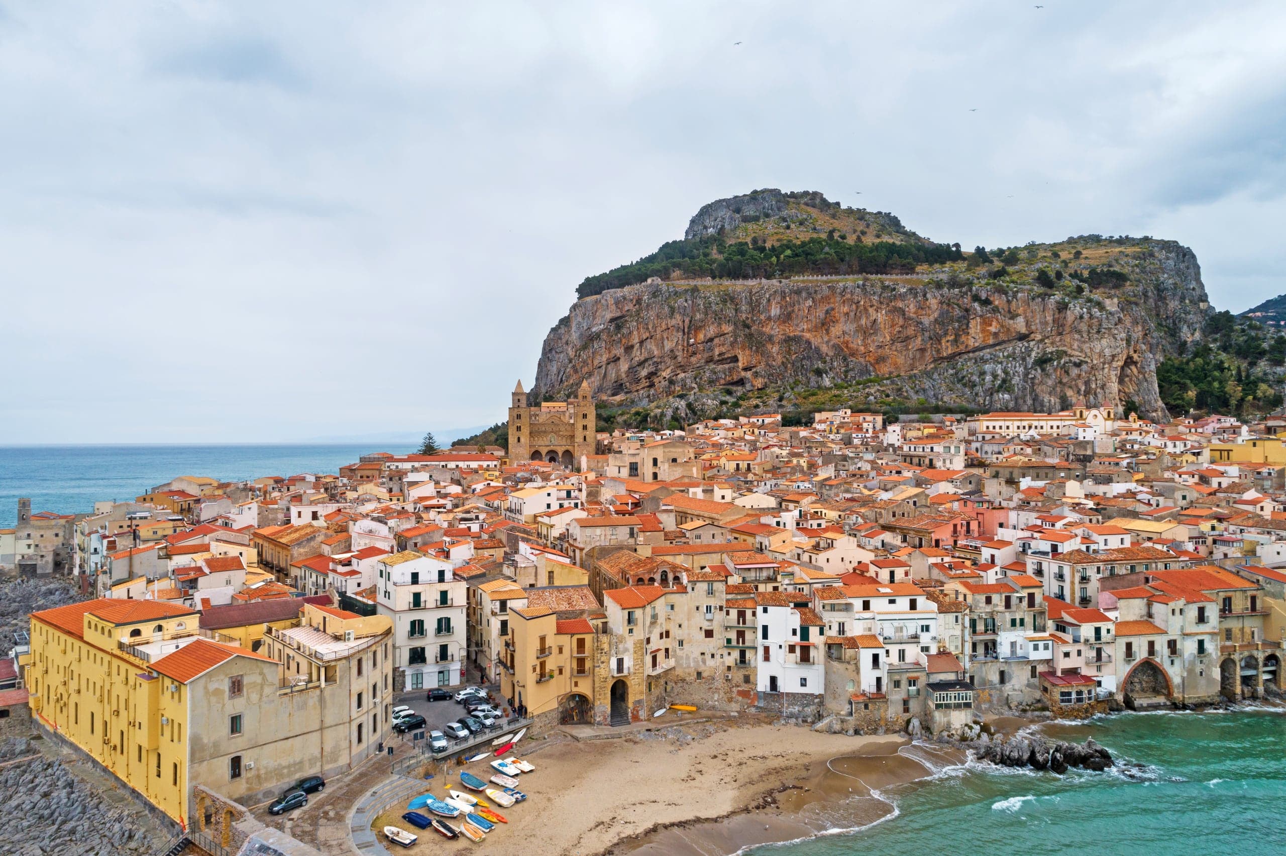 Cefalù's terracotta old town gathered between its rocky headland and the sea